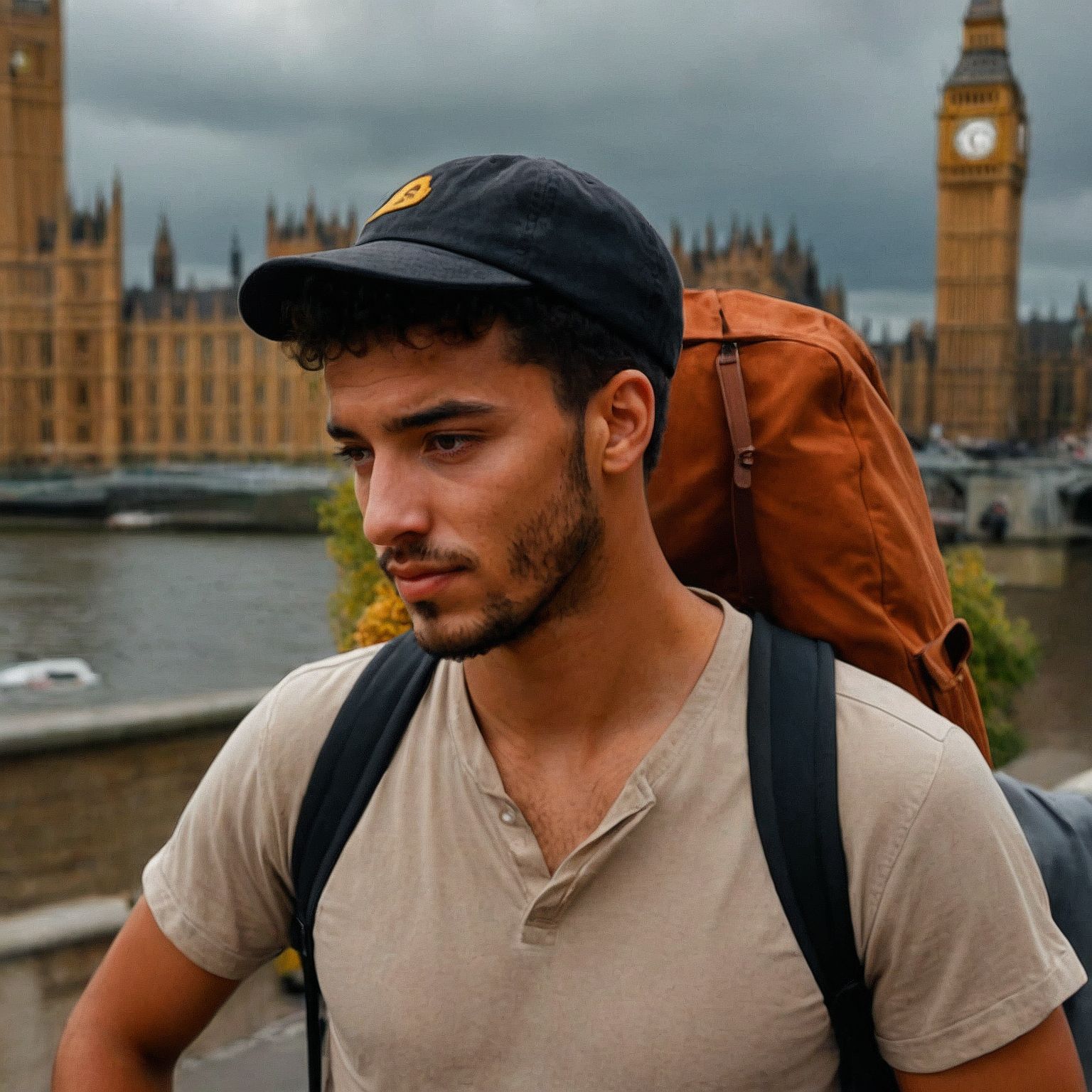 Menajem Pérez walks along the Thames, backpack on, with Big Ben standing tall behind him.